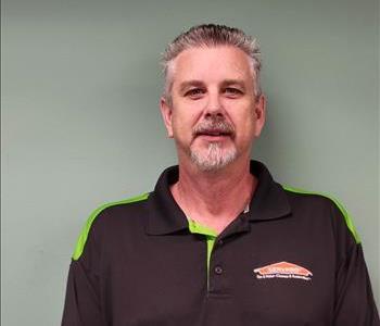 SERVPRO employee in front of gray wall