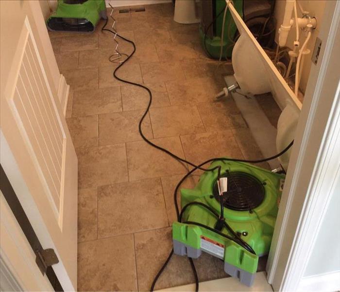 Green air movers on the ground of a tile floor. 