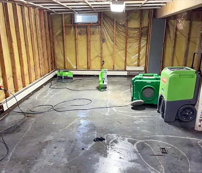 Empty basement after water damage with air movers