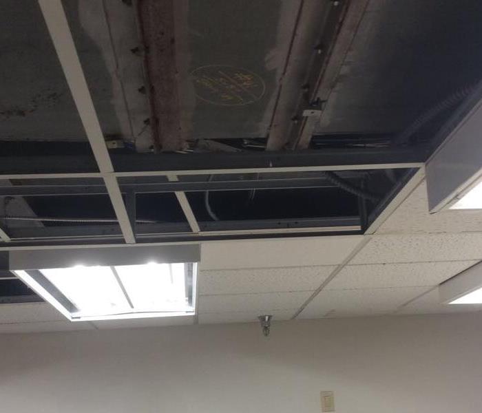 Ceiling tiles removed exposing an open ceiling in an office. 