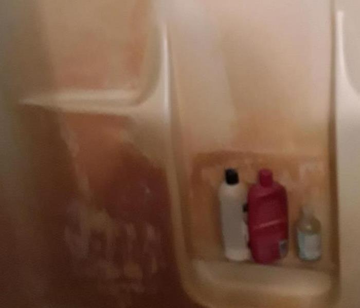 Shower with a reddish discoloration due to mold. 